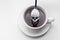 Unhealthy white sugar concept. Scull spoon with sugar and cup of black coffee