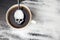 Unhealthy white sugar concept. Scull spoon with sugar and cup of black coffee on wooden background