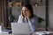 Unhealthy young business lady having strong headache at workplace.