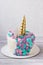 Unicorn cake with a golden horn and colored mane. Cream cake with meringues