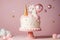 Unicorn cake on a stand decorated with sweets, stars, chocolate for baby girl birthday on a pink background with horse and
