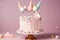 Unicorn cake on a stand decorated with sweets, stars, chocolate for baby girl birthday on a pink background with horse and