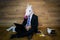 Unicorn in a suit and tie smiles and using laptop and gadgets on wooden background