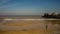 Unidentifiable couple dog walking on Cromer beach on the North Norfolk coast