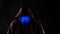 Unidentifiable Male Person in a Hoodie with Blue Covid 19 Mask