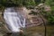 Unidentifiable man relaxing at waterfall in tropical rainforest