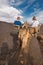 Unidentifiable tourist riding Camels in volcanic landscape in Timanfaya national park, Lanzarote, Canary islands, Spain.