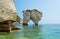 Unidentifiable tourists with kayaks at Faraglioni Di Puglia Baia delle Zagare - famous beach in Italy