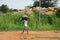 Unidentified african boy carrying a suitcase in his head