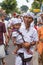 Unidentified balinese man with a child carry offerings for gods during Galungan and Kuningan in Ubud, Bali