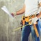 Unidentified builder standing in white gloves with a tool belt w