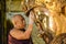 Unidentified Burmese monk is cleaning Buddha statue with the golden paper at Mahamuni Buddha temple, August