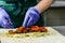 Unidentified chef preparing Falafel roll with sauce, pickles and