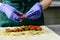 Unidentified chef preparing Falafel roll with sauce, pickles and