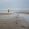 Unidentified child in oilskin jacket on deserted beach