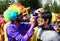 Unidentified Clown painting guy with Batman costume`s face at Orange Blossom Carnival