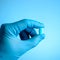 Unidentified doctor hand with latex glove holding a pill or caps