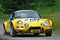 Unidentified drivers on a yellow vintage Alpine Renault racing car
