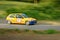 Unidentified drivers on a yellow vintage Renault Clio racing car