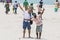 Unidentified family woman man child and caucasian man taking a walk at beautiful sunny morning at Danushkodi beach. Pilgrims from