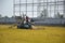 Unidentified farmer harvesting rice in paddy field with harvest car in Chachoengsao, Thailand.