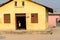 Unidentified Ghanaian girl stands in yellow house in local vill
