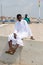 Unidentified Ghanaian man in white clothes sits on the fence in