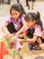 Unidentified girls making sand pagodas with colorful flags in So