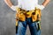 Unidentified handyman with hands on waist and tool belt with con