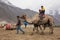 Unidentified Indian tourists riding camels during safari in Nubra valley in Ladakh, India