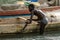 Unidentified local boy holds on the wooden board in the boat