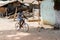 Unidentified local boy rides a bicycle in a village in Guinea B