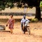 Unidentified local man in a cap rides a motorcycle in a village