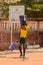 Unidentified local man carries buckets along the road in the ce