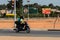 Unidentified local man in helmet rides a motorcycle in a villag