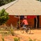 Unidentified local man rides a bicycle in a village in Guinea B