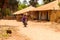 Unidentified local man rides a motocycle in a village in Guinea