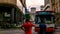 Unidentified local person in red casual clothing is on the phone at the street of Kuala Lumpur. Red bus picking up passenger at