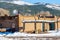 Unidentified man shovels snow from the roof of an adobe house in Taos Pueblo, a Native American settlement continuously inhabited