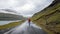 Unidentified man walking in the dramatic road landscape, Faroe Islands