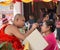 Unidentified monk anoints holy powder on Buddhist forehead, Suphanburi,