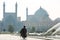 Unidentified Mullah walk towards the Shah Mosque in Isfahan