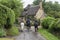 Unidentified people and horses near cottages in the village of Stanton, Cotswolds district of Gloucestershire.