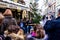 Unidentified people listen musicians playing on Christmas decorated street