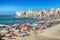 Unidentified people on sandy beach in Cefalu, Sicily, Italy