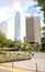 Unidentified people are walking in the park near skyscrapers in Hong Kong