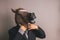 Unidentified person with a dark grey suit and tie wearing a horse mask adjusting the tie
