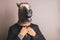 Unidentified person with a dark grey suit and tie wearing a horse mask adjusting the tie