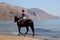 Unidentified rider on a horse on the beach