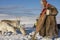 Unidentified Saami man feeds reindeers in harsh winter conditions, Tromso region, Northern Norway.
